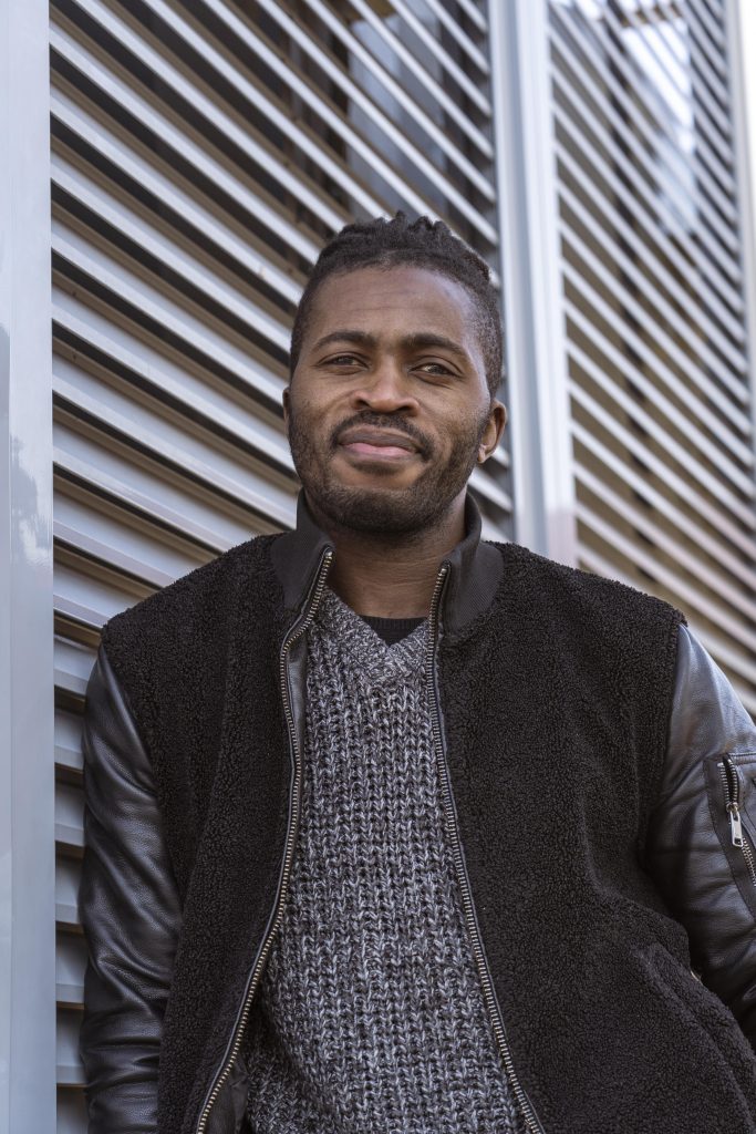 Portrait of a man leaning against a wall, shot from a low angle